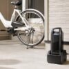 電動自転車のバッテリーを玄関で充電器に接続している様子