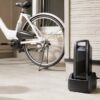電動自転車のバッテリーを玄関で充電器に接続している様子