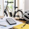 自転車保険義務化を確認する書類とスマートフォンとヘルメット
